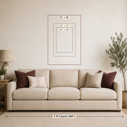 A staged living room scene showing a beige sofa against a cream wall, with a framed size diagram centered above it. The diagram labels three mat/frame sizes (24 x 36, 16 x 24, 12 x 18) and includes a dimension line below the couch reading 7 ft Couch (84 in).